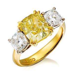 Fancy yellow diamond is balanced by two white diamonds spreading gently across the finger